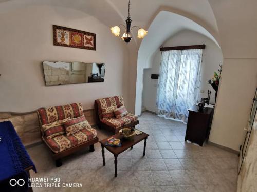 Una sala de estar con dos sofás y una mesa. en Casa Vittoria, en Vignacastrisi