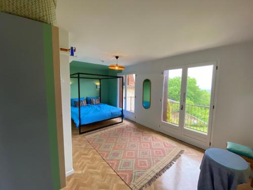 a bedroom with a blue bed and a balcony at Chateau de la Biste in Tourdun