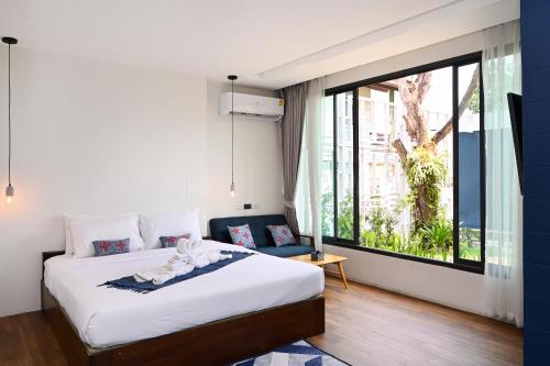 Un pat sau paturi într-o cameră la Villa Mahaphrom
