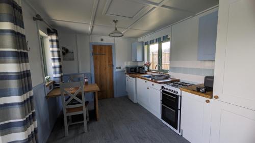 a kitchen with white cabinets and a stove top oven at Lynstone Lakes in Bude