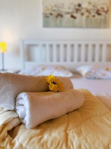 a pile of towels and a flower on a bed at Apartments Vilma in Murter