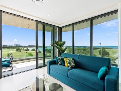 a living room with a blue couch and large windows at Fourteen at Mullet Bay in Cupecoy