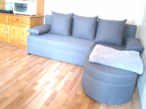 a blue couch in a living room with a wooden floor at Ferienwohnung Pezi in Sankt Primus am Turnersee