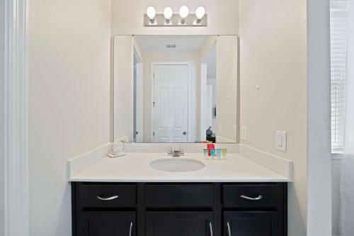 a bathroom with a sink and a mirror at Pool Villa wFREE Resort Access Great Reviews in Kissimmee