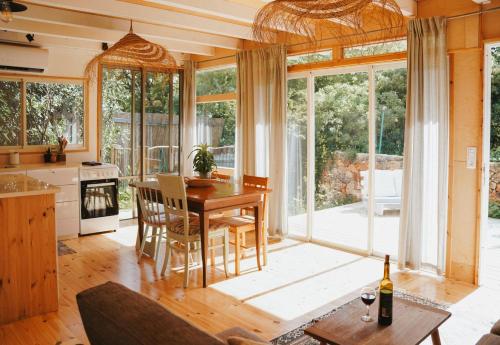 a kitchen and dining room with a table and chairs at Jasmine House in Amirim