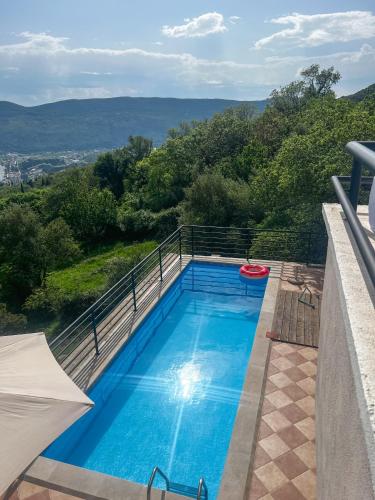 a blue swimming pool with a frisbee on a balcony at Villa Tre Tri in Herceg-Novi