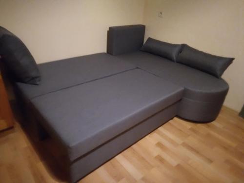 a gray couch in a room with a wooden floor at Ferienwohnung Pezi in Sankt Primus am Turnersee