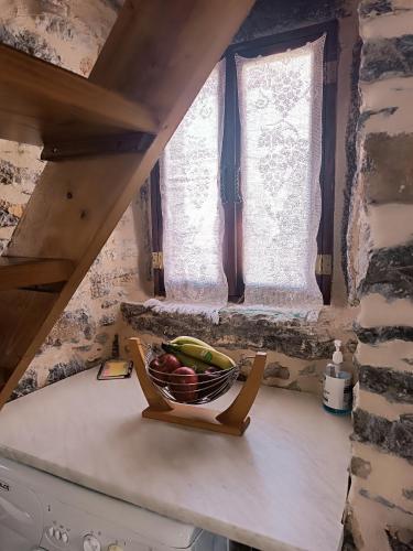 a bowl of fruit on a counter next to a window at ΜΕΣΤΑ - ΠΛΑΤΕΙΑ in Mesta