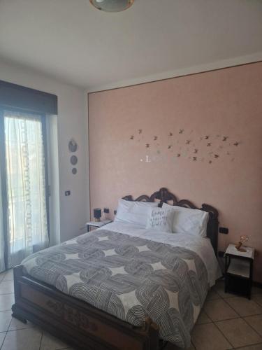 1 dormitorio con 1 cama grande con pájaros en la pared en Iris, en Cislago