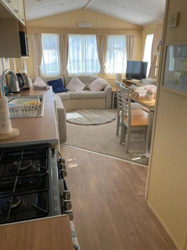 a kitchen and living room of a caravan at Cosy 2 bed pet friendly holiday home Crantock Nr Newquay in Crantock