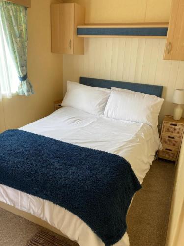 a bedroom with a bed with a blue blanket on it at Cosy 2 bed pet friendly holiday home Crantock Nr Newquay in Crantock