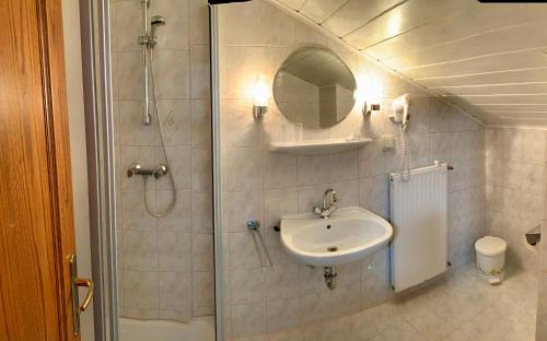 a bathroom with a shower and a sink and a mirror at Pension Miklautz in Sankt Kanzian