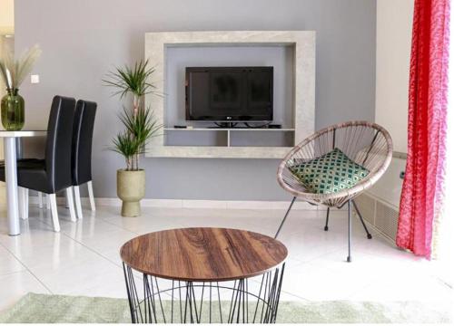 a living room with a tv and a table and chairs at Apartments Grand Pinea in Čilipi