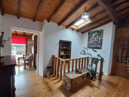 sala de estar con suelo de madera y escalera en La Casa de las rocas - Ribeira Sacra, en Rubiacós