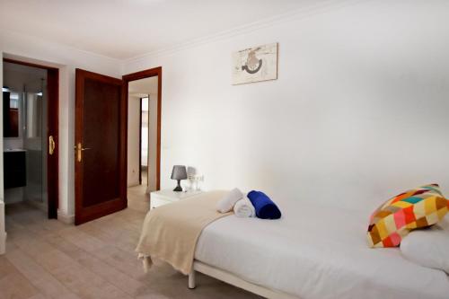 a white bedroom with a large bed and a door at Villa Marbella by Slow Villas in Playa de Palma