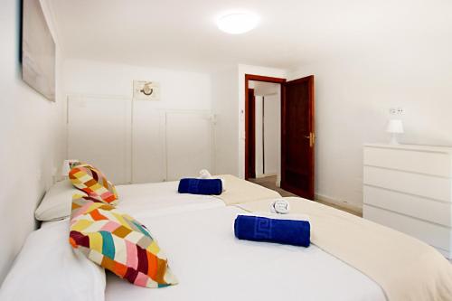 two beds in a room with white walls at Villa Marbella by Slow Villas in Playa de Palma