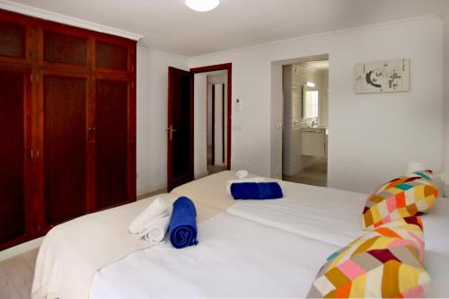 a bedroom with a large white bed with blue pillows at Villa Marbella by Slow Villas in Playa de Palma