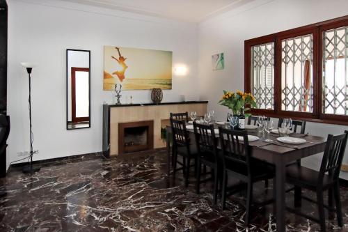 a dining room with a table and chairs and a fireplace at Villa Marbella by Slow Villas in Playa de Palma