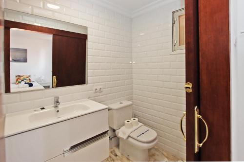 a bathroom with a sink and a toilet and a mirror at Villa Marbella by Slow Villas in Playa de Palma