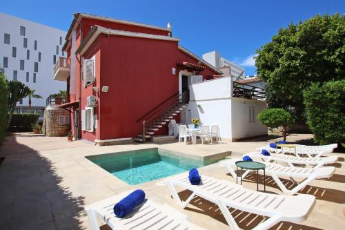 a group of chairs and a swimming pool next to a building at Villa Marbella by Slow Villas in Playa de Palma