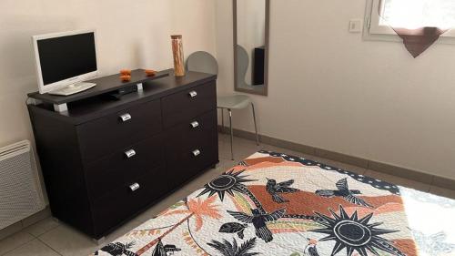 - une chambre avec une commode et un ordinateur dans l'établissement Appartement La Villa Gayrou, à Vieux-Boucau-les-Bains