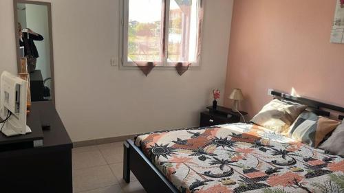 1 dormitorio con 1 cama con edredón en Appartement La Villa Gayrou, en Vieux-Boucau-les-Bains