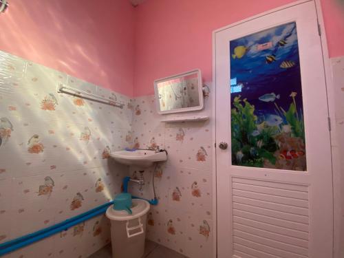 baño con lavabo y mural de pescado en Kanitta Homestay, en Ban Bang Chak