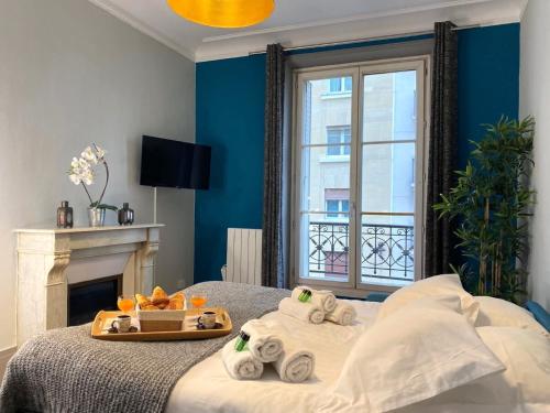 um quarto com uma cama e uma bandeja de toalhas em 1609 - Eiffel Tower Haven Olympic Games 2024 em Paris