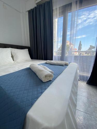 a bed with two pillows on it in a room with a window at Uka apartment in Nea Iraklia