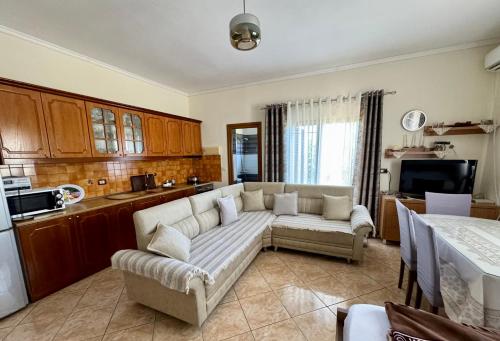 a living room with a couch and a kitchen at Vila Paza in Sarandë