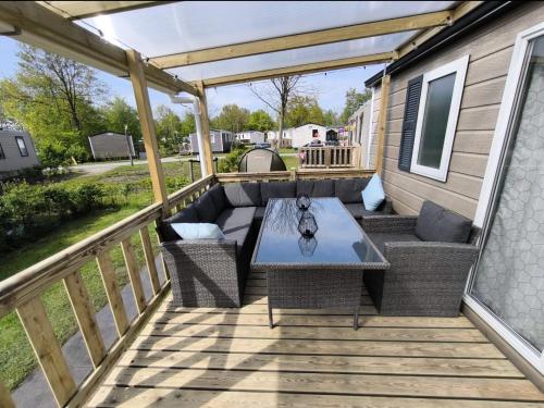 a patio with a table and chairs on a deck at Ferienhaus Chalet Ferienpark Lauwersoog NL in Lauwersoog