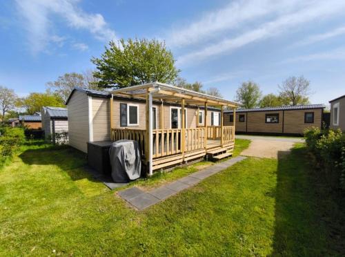 a tiny house is sitting in a yard at Ferienhaus Chalet Ferienpark Lauwersoog NL in Lauwersoog