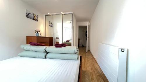 ein Schlafzimmer mit einem Bett mit vier Kissen darauf in der Unterkunft Shoreditch Liverpool Street Apartments with lift and balcony in London