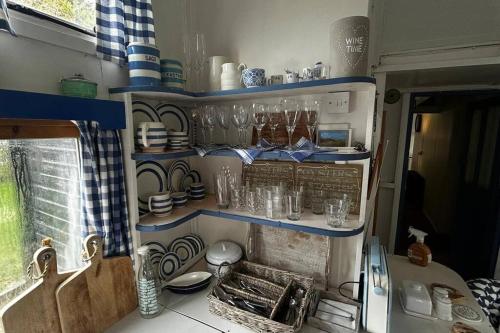 uma cozinha com um lavatório e prateleiras com pratos em Sandy Creek em Humberston