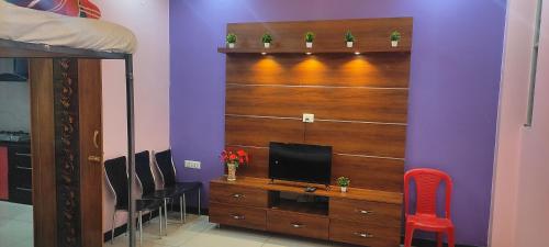 una habitación con un tocador con TV. en ADH Amilia Residency, en Mysore