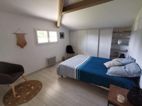 une chambre avec un lit, une chaise et une fenêtre dans l'établissement Villa piscine chauffée dans un écrin de verdure, à Biscarrosse