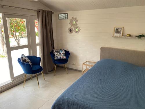 a bedroom with two blue chairs and a bed at Secret Garden Chalet No. 1 in San Pietro in Bevagna