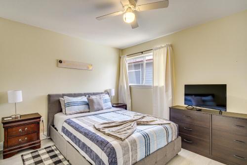een slaapkamer met een bed en een flatscreen-tv bij Airy Biloxi Condo with Patio Walk to Beach! in Biloxi