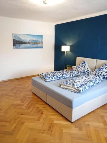 a bedroom with a bed with blue and white pillows at Ferienwohnung Allgäu 3 in Memmingen