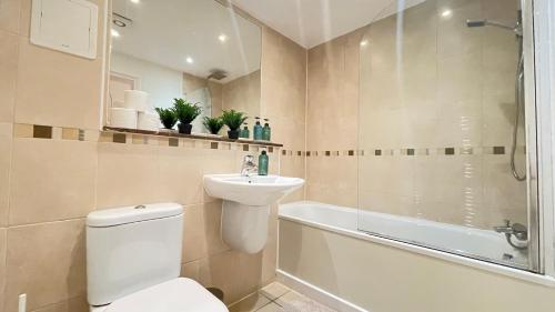 a bathroom with a toilet and a sink and a bath tub at Shoreditch Liverpool Street Apartments in London