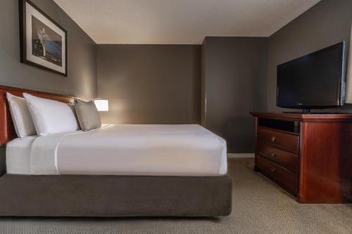 a bedroom with a bed and a flat screen tv at Hotel Faubourg Montreal Centre-Ville Downtown in Montréal