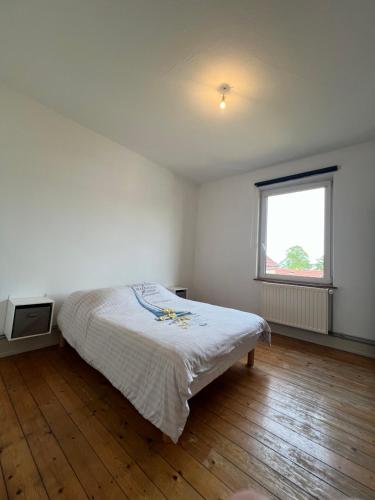 Schlafzimmer mit einem Bett und einem Fenster in der Unterkunft Appartement spacieux Schilk in Straßburg