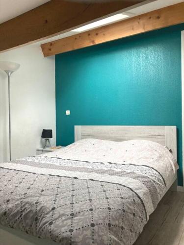 une chambre avec un lit avec un mur bleu dans l'établissement Villa confortable au calme en résidence vacances, à Calvisson