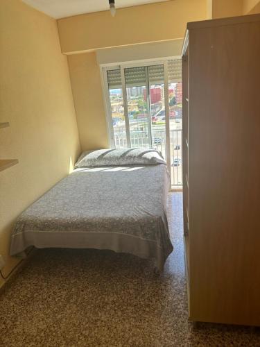 a bedroom with a bed and a large window at Alojamiento K&K Habitacion encasa particular in Valencia