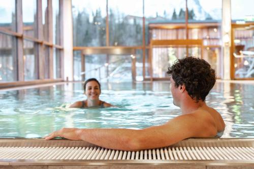 a man and a woman in a swimming pool at SPA Hotel Erzherzog Johann in Bad Aussee