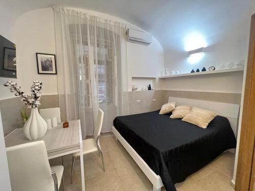 a bedroom with a bed and a table and a desk at MACA HOUSE in Bari