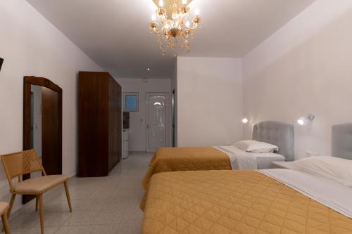 a bedroom with two beds and a chandelier at Hotel Villa Basil in Tsilivi