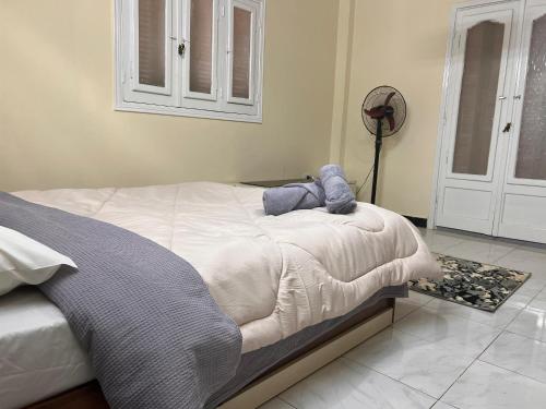 um quarto com uma cama com um bicho de peluche em 2Brs Downtown Heliopolis l Near services no Cairo