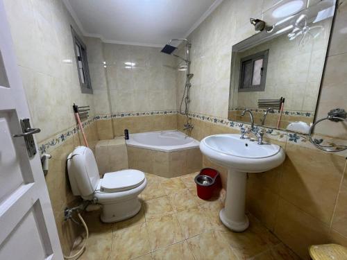 uma casa de banho com um WC, um lavatório e uma banheira em 2Brs Downtown Heliopolis l Near services no Cairo