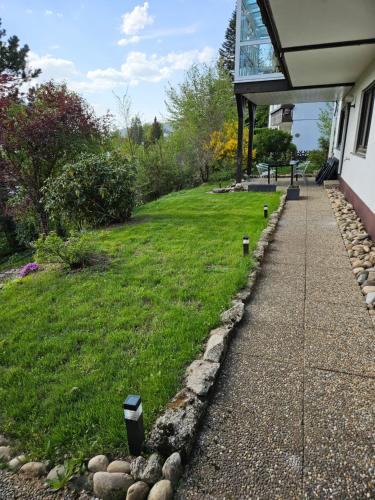 a walkway next to a yard with a building at Große Ferienwohnung in ruhiger Lage mit toller Aussicht in Triberg in Triberg